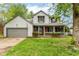 Charming two-story home with a covered porch, attached garage, and manicured lawn at 1113 Delray Dr, Indianapolis, IN 46241