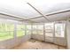 A rustic sunroom with wood floors and multiple windows and a door at 1113 Delray Dr, Indianapolis, IN 46241