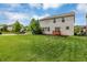 View of backyard and home exterior with a well-maintained lawn, and a ground-level deck offering serene outdoor enjoyment at 11849 Traymoore Dr, Fishers, IN 46038