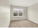 This bedroom has a window providing ample natural light and neutral carpeting at 11849 Traymoore Dr, Fishers, IN 46038