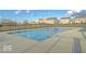 Community pool surrounded by a secure fence and sidewalks, with neighborhood homes in the background on a sunny day at 11849 Traymoore Dr, Fishers, IN 46038