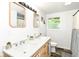 Well-lit bathroom featuring a double sink vanity with modern fixtures and a window view at 1248 Hathaway Dr, Indianapolis, IN 46229