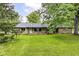 Ranch-style home features a well-maintained lawn, brick facade, and mature trees providing shade and curb appeal at 1248 Hathaway Dr, Indianapolis, IN 46229