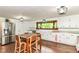 Bright kitchen features white cabinets, hardwood floors, stainless steel appliances, and a large picture window at 1248 Hathaway Dr, Indianapolis, IN 46229
