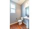 Powder room features pedestal sink, toilet, and window for natural light; vinyl flooring at 12672 Amber Star Dr, Noblesville, IN 46060