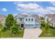 Charming two-story home with blue siding, well-manicured lawn, and a three-car garage at 12672 Amber Star Dr, Noblesville, IN 46060