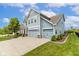 Side angle view of a beautiful light blue home featuring a spacious three-car garage and manicured landscaping at 12672 Amber Star Dr, Noblesville, IN 46060