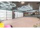 Spacious garage featuring bright hexagon lighting, epoxy floors, and wall-mounted organization for tools and equipment at 12672 Amber Star Dr, Noblesville, IN 46060
