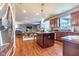 Modern kitchen with stainless steel appliances, island seating, and hardwood floors open to the dining room at 12672 Amber Star Dr, Noblesville, IN 46060
