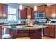 Well-equipped kitchen features wood cabinets, stainless steel appliances and a center island with pendant lighting at 12672 Amber Star Dr, Noblesville, IN 46060
