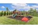 Large wooden playset with slide and swing set on the landscaped backyard, offering hours of fun at 12672 Amber Star Dr, Noblesville, IN 46060