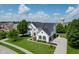 Aerial view of a two-story home featuring lush landscaping, a shingled roof and private driveway at 13218 Beckwith Dr, Carmel, IN 46074