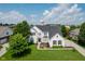 Aerial view of a two-story home with lush landscaping, charming curb appeal and a shingled roof at 13218 Beckwith Dr, Carmel, IN 46074