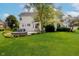 Large, manicured backyard with a white house, patio, hot tub, and well-kept lawn at 13218 Beckwith Dr, Carmel, IN 46074