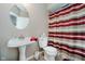 Compact bathroom featuring a pedestal sink, toilet, and a shower with a patterned curtain at 13218 Beckwith Dr, Carmel, IN 46074