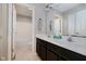 Bright bathroom featuring a double sink vanity, large mirror, and neutral toned walls and flooring at 13218 Beckwith Dr, Carmel, IN 46074