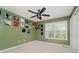 A bedroom with an olive green wall, ceiling fan, and curated décor and posters at 13218 Beckwith Dr, Carmel, IN 46074