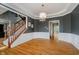 Open dining room featuring hardwood floors, decorative chandelier, wainscoting and staircase at 13218 Beckwith Dr, Carmel, IN 46074