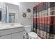 Cozy bathroom featuring a white vanity, toilet, and decorative wall art near a striped shower curtain at 13321 N White Cloud Ct, Camby, IN 46113