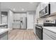 Modern kitchen features stainless steel appliances, gray cabinets, and light wood flooring at 13321 N White Cloud Ct, Camby, IN 46113