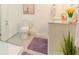 Modern bathroom featuring a tiled shower, toilet, vanity with a granite countertop, mirror, and a decorative plant at 1398 Clinton St, Noblesville, IN 46060