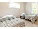 Comfortable bedroom with two beds, carpeted floors, two windows, and neutral tones and a striped comforter at 1398 Clinton St, Noblesville, IN 46060