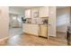 Bright kitchen featuring white cabinets, stainless steel dishwasher, and a view into the living area at 1398 Clinton St, Noblesville, IN 46060