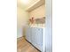 Bright laundry room with modern white washer and dryer and a wire shelf for convenient storage, wood-look flooring at 1398 Clinton St, Noblesville, IN 46060