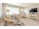 Inviting living room showcasing neutral tones, plush seating, and natural light through sheer curtained windows at 1398 Clinton St, Noblesville, IN 46060