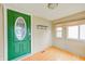 Inviting entrance area features a striking green door, light-colored walls, and gleaming hardwood floors at 148 S 3Rd Ave, Beech Grove, IN 46107
