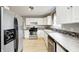 Well-lit kitchen with stainless steel appliances, white cabinetry, and hardwood flooring at 148 S 3Rd Ave, Beech Grove, IN 46107