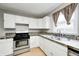 Efficient kitchen featuring stainless steel appliances, white cabinets, hardwood flooring and mosaic backsplash at 148 S 3Rd Ave, Beech Grove, IN 46107