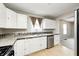 Functional kitchen featuring white cabinets, stainless steel dishwasher, and hardwood floors at 148 S 3Rd Ave, Beech Grove, IN 46107