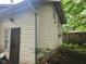 Exterior side view of home with light siding, with lush green trees and partial fence at 1624 E 30Th St, Indianapolis, IN 46218