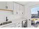 A bright bar area with a sink, wine fridge and storage that walks out to a rooftop patio at 1816 Rosette Way, Indianapolis, IN 46202