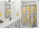 A bathroom with a white vanity, black hardware, and a shower with a decorative shower curtain at 1816 Rosette Way, Indianapolis, IN 46202