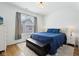 Bright bedroom featuring a cozy blue quilt, a window view, and stylish hardwood floors at 1816 Rosette Way, Indianapolis, IN 46202