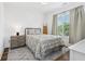 Sunlit bedroom features stylish decor, a comfortable bed, and a window with tree views at 1816 Rosette Way, Indianapolis, IN 46202