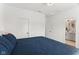 Cozy bedroom featuring a blue quilt and ensuite bathroom with white cabinetry at 1816 Rosette Way, Indianapolis, IN 46202