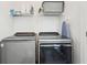 Laundry room featuring modern washer and dryer units with wire rack shelving above at 1816 Rosette Way, Indianapolis, IN 46202
