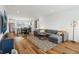 Open-concept living room with gray sectional, wood floors, and stainless kitchen appliances at 1816 Rosette Way, Indianapolis, IN 46202