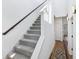 A staircase with carpeted steps, a wooden handrail and wall lighting at 1816 Rosette Way, Indianapolis, IN 46202