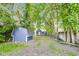 Large backyard with a blue storage shed, surrounded by mature trees, and a well-maintained lawn at 1822 Howard St, Indianapolis, IN 46221