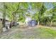Spacious backyard features a blue shed with white doors, trees and well-maintained lawn at 1822 Howard St, Indianapolis, IN 46221