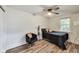Bright bedroom features wood-look floors, stylish ceiling fan, a comfortable chair and window for natural light at 1822 Howard St, Indianapolis, IN 46221