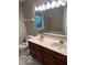 Bathroom featuring double vanity sinks, a toilet, a shower over bath, and a large mirror at 1941 Spruce Dr, Carmel, IN 46033