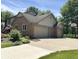 Charming brick home featuring a three-car garage, well-maintained landscaping, and a spacious driveway for easy access at 1941 Spruce Dr, Carmel, IN 46033