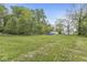 A large grassy backyard with a swimming pool, shed and chain link fence surrounding it at 2 S 25Th Ave, Beech Grove, IN 46107