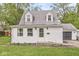 Charming cottage-style home with white siding, dormer windows, green lawn, and attached garage at 2 S 25Th Ave, Beech Grove, IN 46107