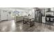 Open floor plan showcasing kitchen with stainless steel appliances, island, and wood-look flooring at 2 S 25Th Ave, Beech Grove, IN 46107